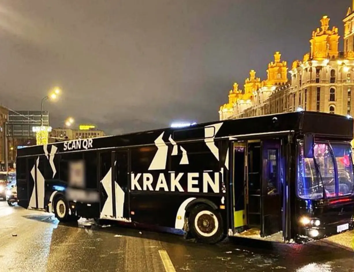 Чёрный автобус с символикой Kraken на улице Москвы; QR-код на опубликованном изображении размыт